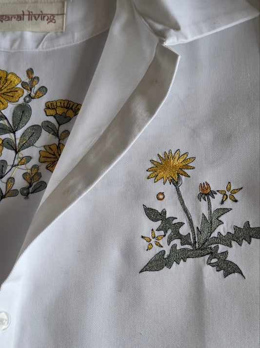 White shirt with floral embroidery on a light gray background